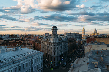 Cityscape of Neoclassicism residential house with tower on Five Corners square in St Petersburg, Russia. Cloudy sunset sky. Beautiful landscape. Vladimirsky Cathedral on background. Travel destination