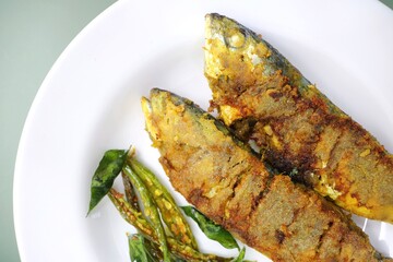 Indian Mackerel fish fry. Bangda Rava fry. whole Fried fish served on a banana leaf with fried...