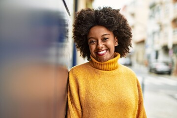 Fototapeta premium Young african american girl smiling happy standing at the city.