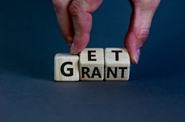 Get grant symbol. Businessman turns wooden cubes with concept words 'Get grant' on a beautiful grey background. Copy space. Business and get grant concept.