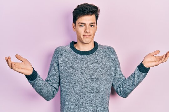 Young hispanic man wearing casual clothes clueless and confused with open arms, no idea and doubtful face.