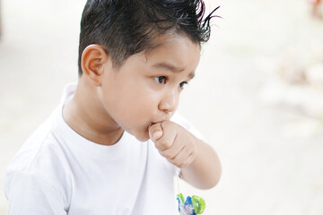 Portrait of cute happy Asian kid looking some one around.