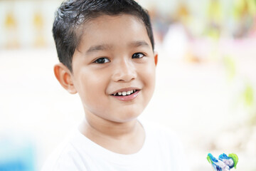 Portrait of cute happy Asian kid looking some one around.