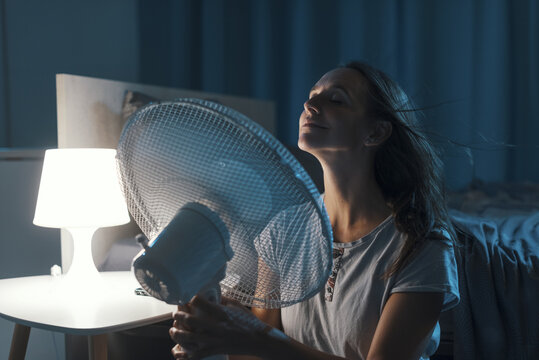 Woman enjoying fresh air in front of a fan