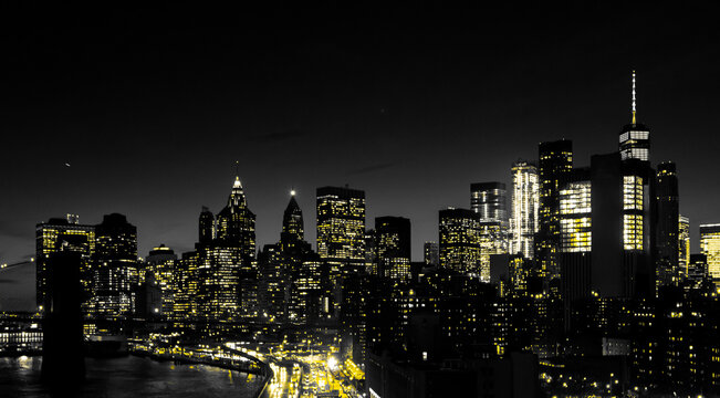 Fototapeta Red lights of Manhattan night skyline shining against a black and white cityscape of downtown New York City