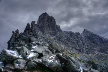 Rock mass on the background of the cloudy sky.