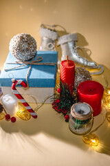 New year atmosphere New Year's gift, candle and Christmas toys, garland on yellow background. X-mas things