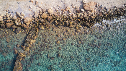 Beautiful birdsview with a drone on the beach, rocks, sand, sea and waves.