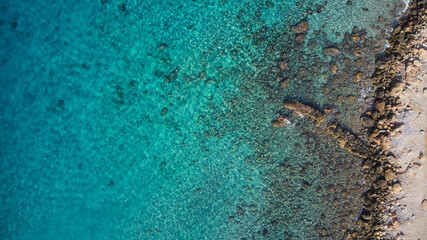 Beautiful birdsview with a drone on the beach, rocks, sand, sea and waves.