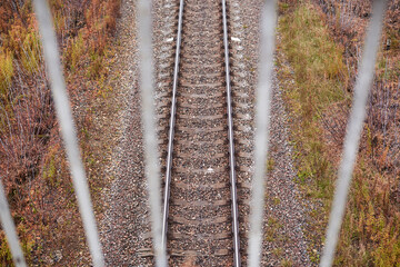 View of the railway through the bridge fence