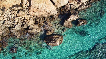 Beautiful birdsview with a drone on the beach, rocks, sand, sea and waves.