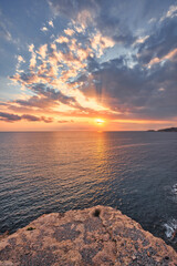 Beautiful sunset with a dramatic sky and clouds over the sea and cliffs