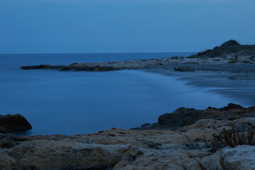 Long exposure image of Dramatic sky and wave seascape with rock in sunset scenery background