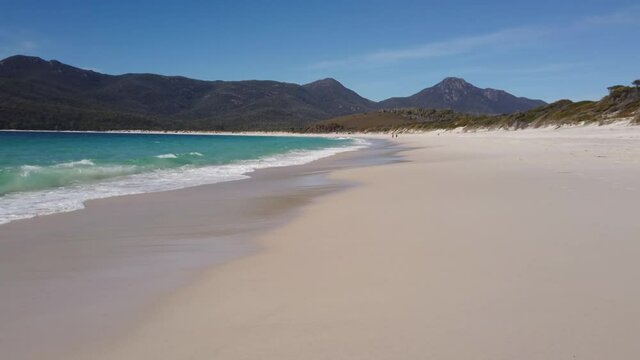 Left to right pan motion of Wineglass Bay beach near water's edge in the Freycinet national Park,Tasmania, Australia