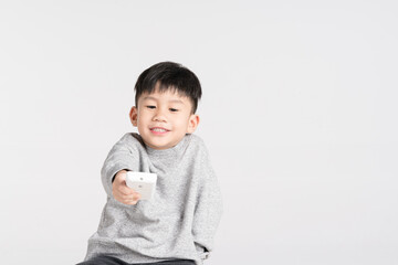 Asian boy holding air conditioner remote