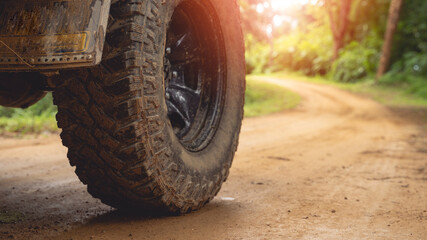 The off-road vehicle's side On a gravel road, an off-road vehicle is parked. In the middle of a beautiful forest