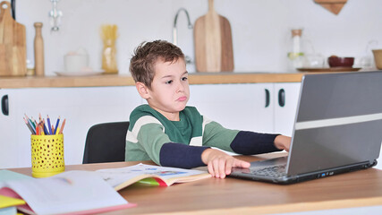 boy is studying at an online school, showing the answer to the question via video communication