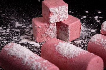 Pink homemade plum marshmallow on black background