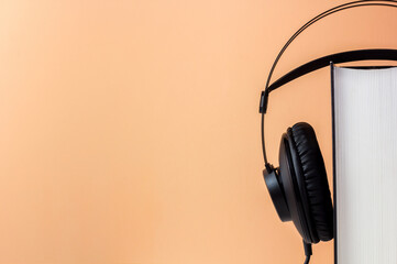 Headphones on book. Audiobook horizontal banner with copyspace. Online education and e-learning concept