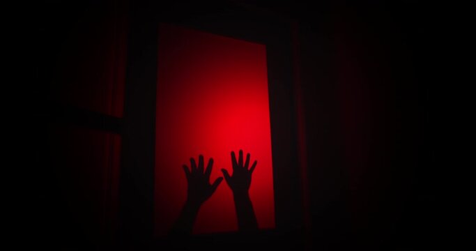 Two hands bang on a window