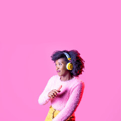 Young curly hair black woman isolated dancing listening music with wireless headphones clubbing and partying