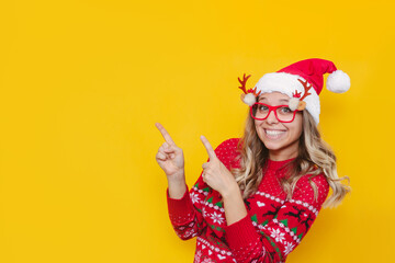 A young smiling blonde woman in a red Christmas sweater, glasses with deer antlers and a red...