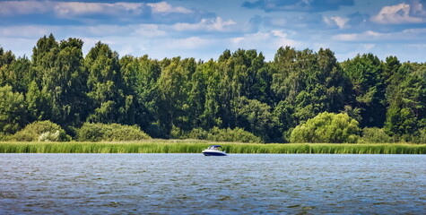 Summer landscape with river, boat, trees and sky with clouds