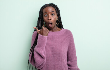 black pretty woman looking astonished in disbelief, pointing at object on the side and saying wow,...