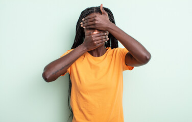 black pretty woman covering face with both hands saying no to the camera! refusing pictures or...