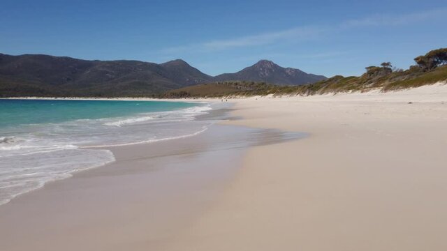Right to left pan motion of Wineglass Bay beach near water's edge in the Freycinet national Park,Tasmania, Australia