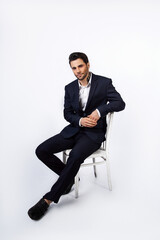 handsome young man sitting in a dark blue suit