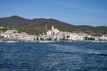 Fototapeta na wymiar View of Cadaques with the church bell and white houses from a boat, Catalonia, Spain