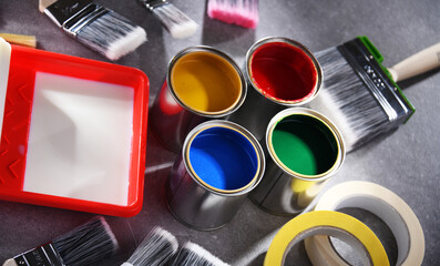 Paintbrushes of different size and paint cans