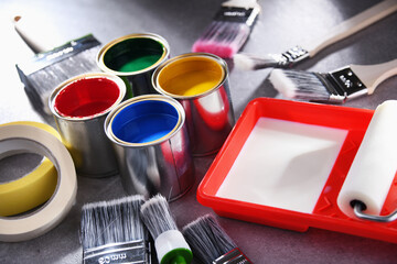 Paintbrushes of different size and paint cans