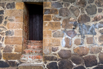 die Treppensufen aus Stein führen zu einer alten Holztür in der Mauer