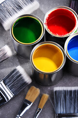 Paintbrushes of different size and paint cans