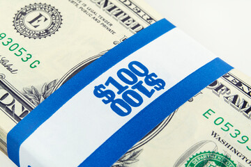 One hundred dollar money bundle with paper currency strap. © trekandphoto