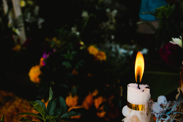 Candle light with cempasuchil flower on the background: Detail of día de muertos festivity (translated as day of the dead) altar in Mexico