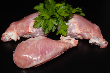 Pieces of turkey drumsticks without skin. Organic turkey meat with greens