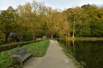Chemin entre le mur d'enceinte et l'étang du Moulin vers l'une des portes d'entrée de l'abbaye du Rouge Cloître sous un feuillage dorée à Auderghem