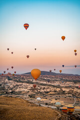 Vertical shot of colorful hot air balloons flying over Cappadocia, Turkey during sunset