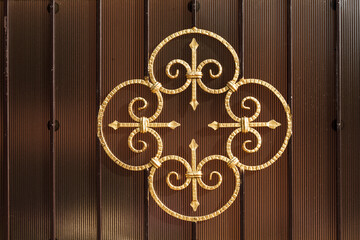 Metal forged pattern painted with gold color paint, decorating a fence or gate