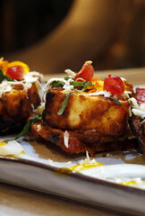 Trozos de berenjena asados al horno y rebozados con tomate, cebolla, pimientos, jengibre, semillas de mostaza al estilo de la india
