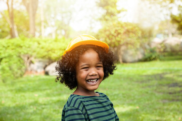 Portrait of African American boy wearing safety hat playing in the park with happy and smile