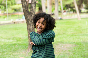 Naklejka na ściany i meble Portrait of African American boy playing in the park with happy and smile