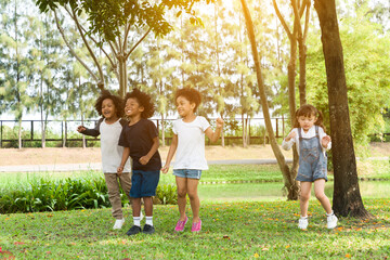 Group of diversity kids playing cheerful in the park. Children having fun and jumping with rope in the garden.