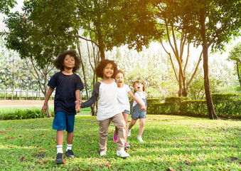 Fototapeta premium Group of diversity kids playing cheerful in the park. Children having fun and jumping with rope in the garden.