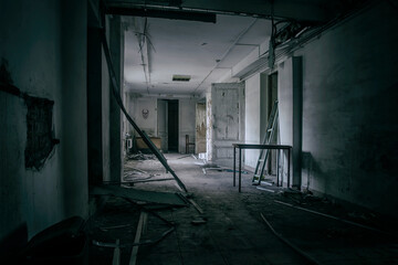 Scary empty dark corridor in an abandoned building. Shabby walls. The play of light and shadows in an abandoned house. Broken doors. An old abandoned hospital. The interior of an abandoned house.