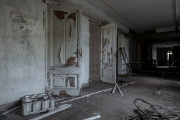 Scary empty dark corridor in an abandoned building. Shabby walls. The play of light and shadows in an abandoned house. Broken doors. An old abandoned hospital. The interior of an abandoned house.