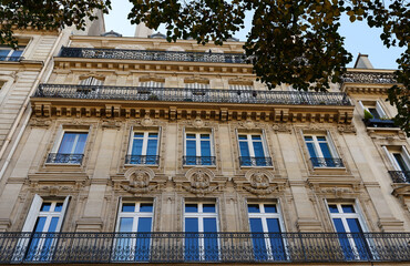 Obraz premium The facade of traditional French house with typical balconies and windows. Paris.